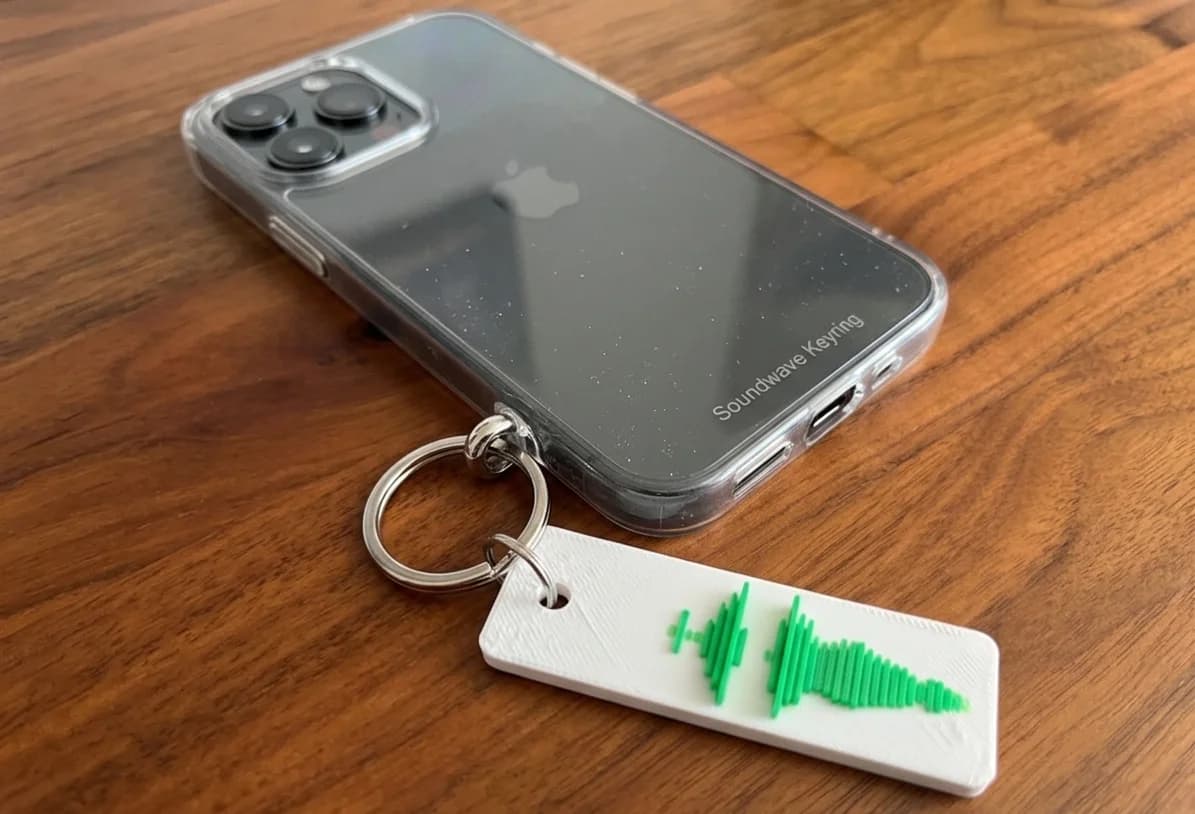 VoicePrint3D keychain next to a phone